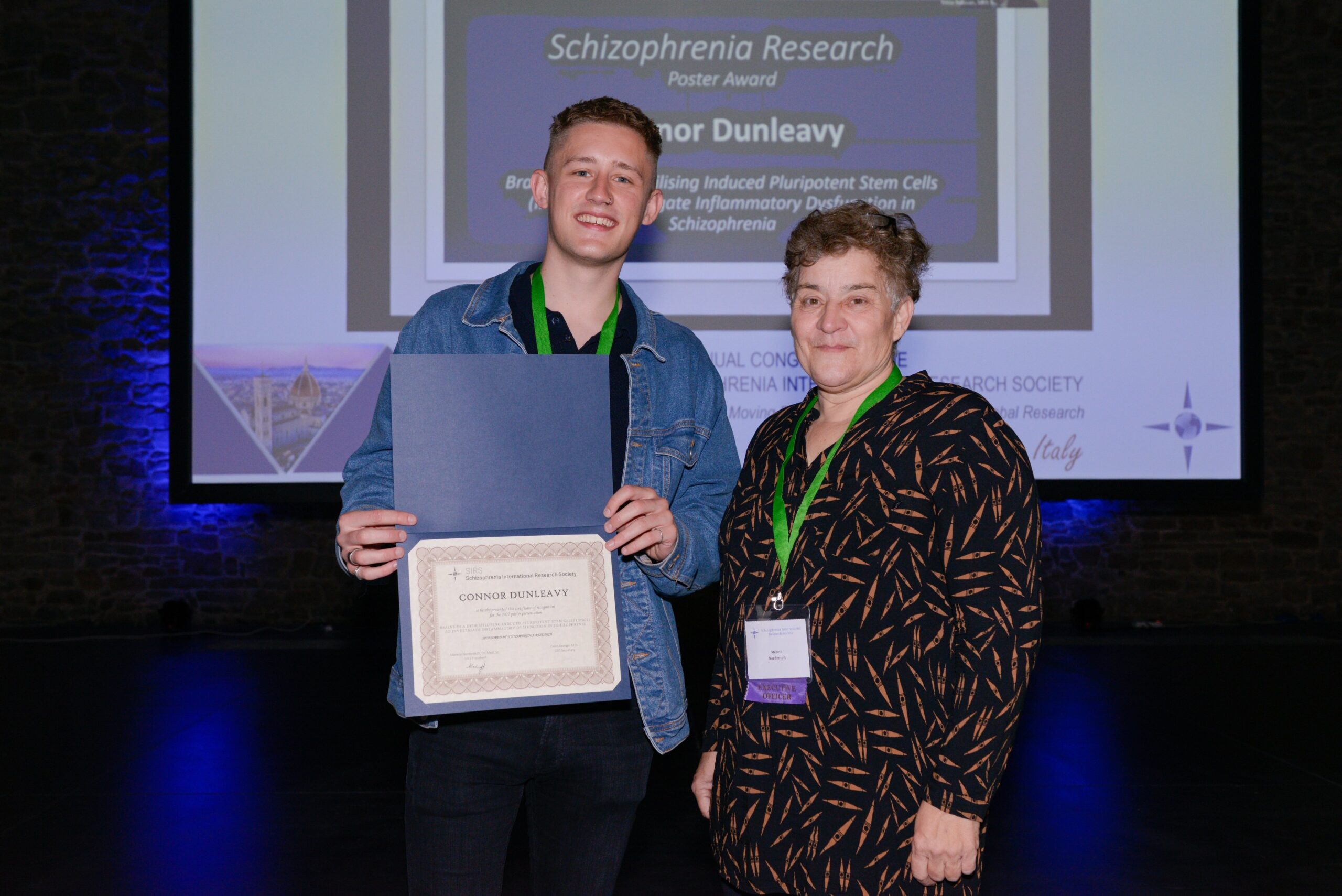 Connor Dunleavy with a certificate of recognition for receiving a Schizophrenia Research Poster Award from the Schizophrenia International Research Society.